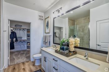A bathroom with a white sink and a mirror above it.